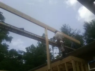 Carpenter setting a ridge beam over a new addition frame — Ice Dam Removal by Roofing Brothers in East Moriches