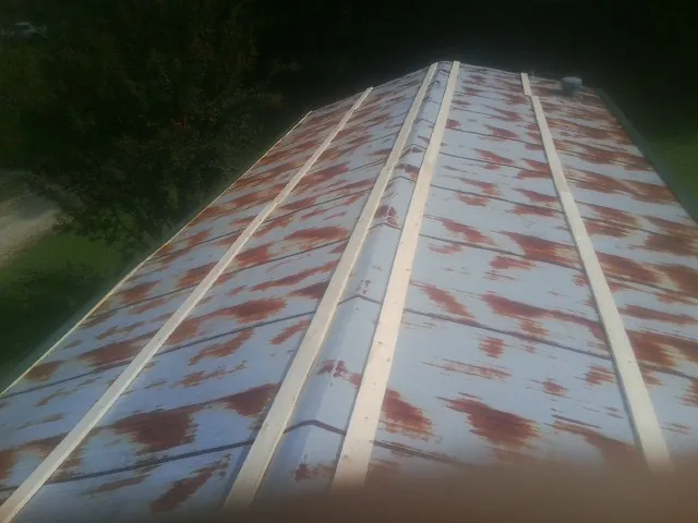 Rusted metal roof panels with new wood purlins before replacement — Storm Damage Roof Repair in East Moriches by Roofing Brothers