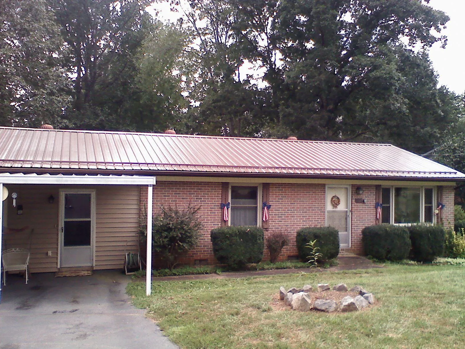 Bronze metal roof and carport on a brick ranch home — Roof Repair work by our crew in East Moriches